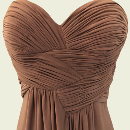 Brown strapless dress with pleated details on a beige background
