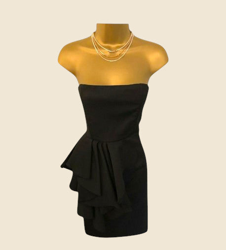 Black strapless dress on a gold mannequin with a beige background