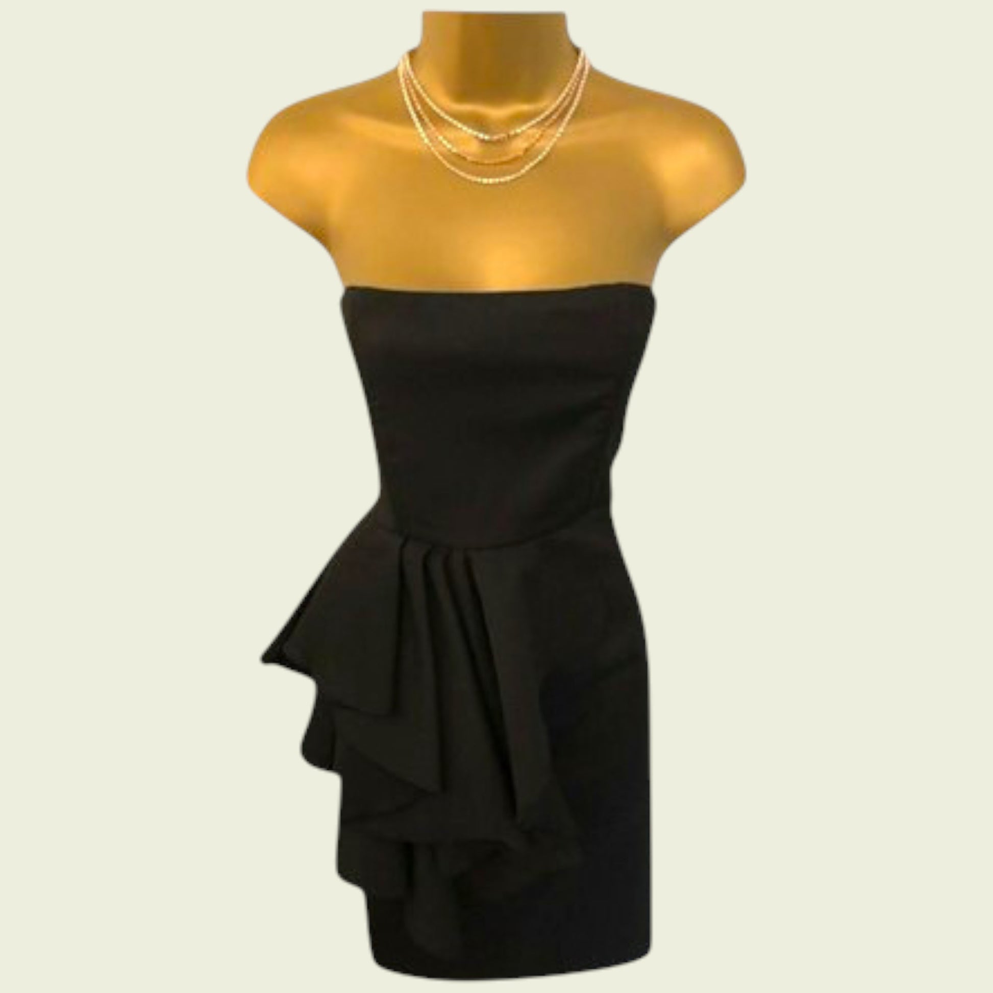 Black strapless dress on a mannequin with a plain background