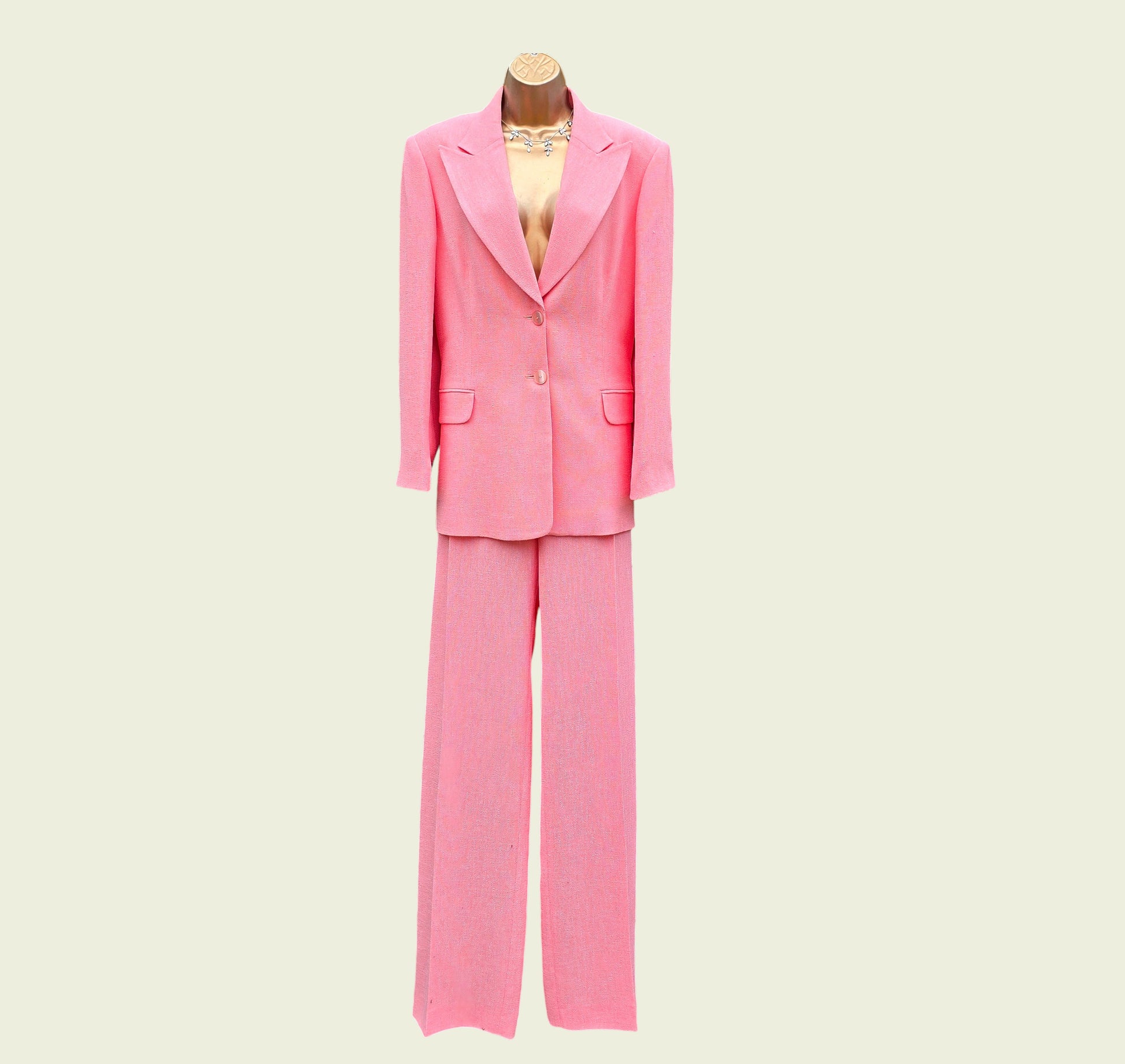 Pink suit on a mannequin against a beige background