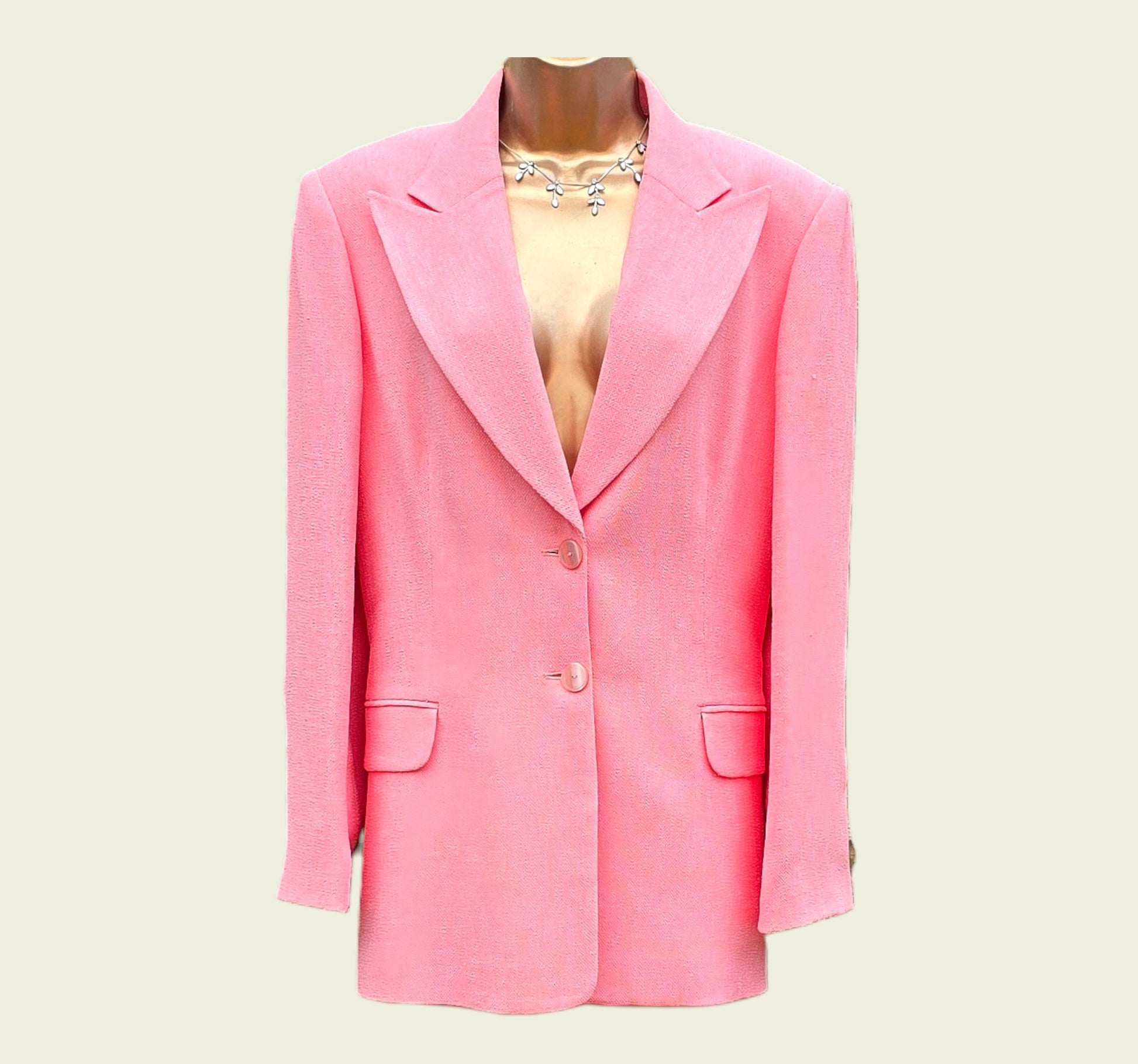 Pink blazer on a mannequin against a light beige background