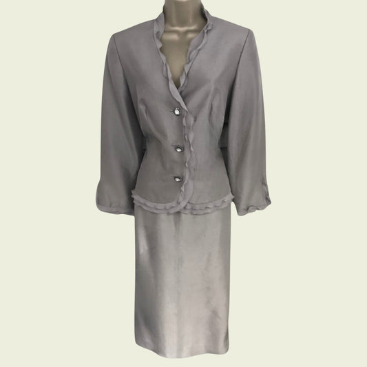 Mannequin wearing grey silk skirt and jacket on beige background
