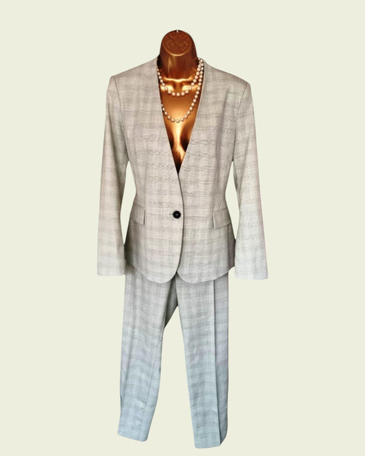 Plaid suit on a mannequin with a pearl necklace against a beige background