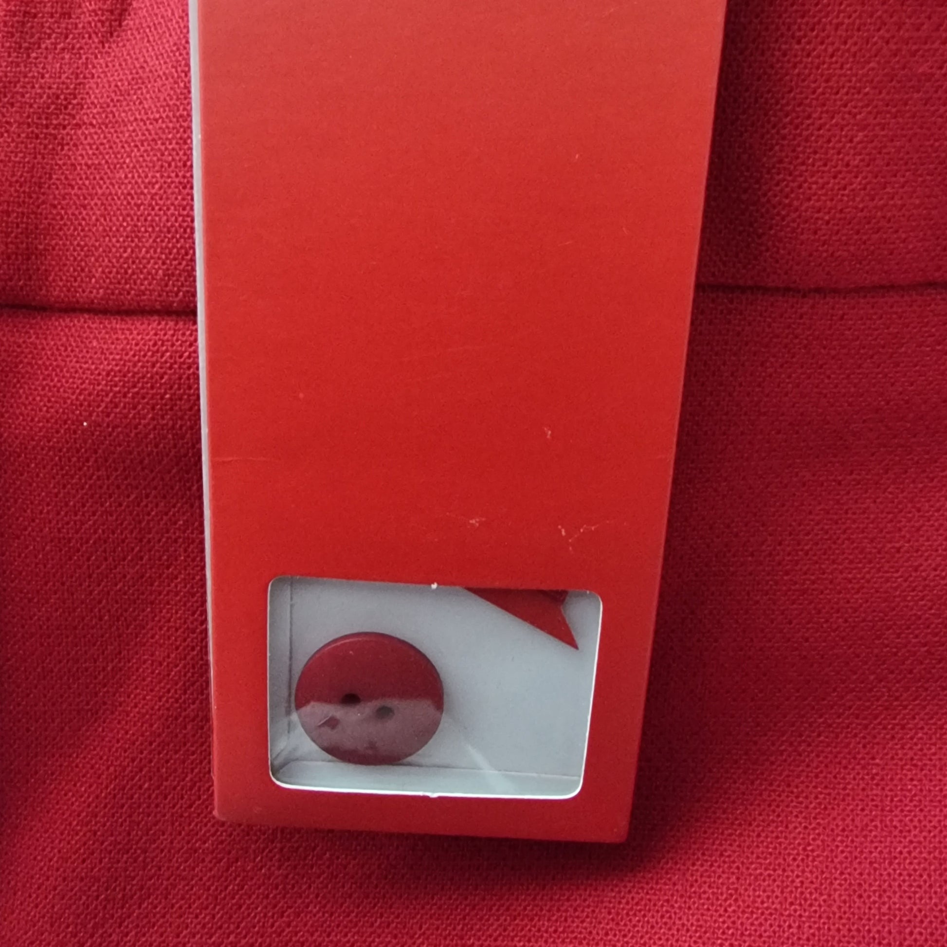 Label containing red spare button on red background