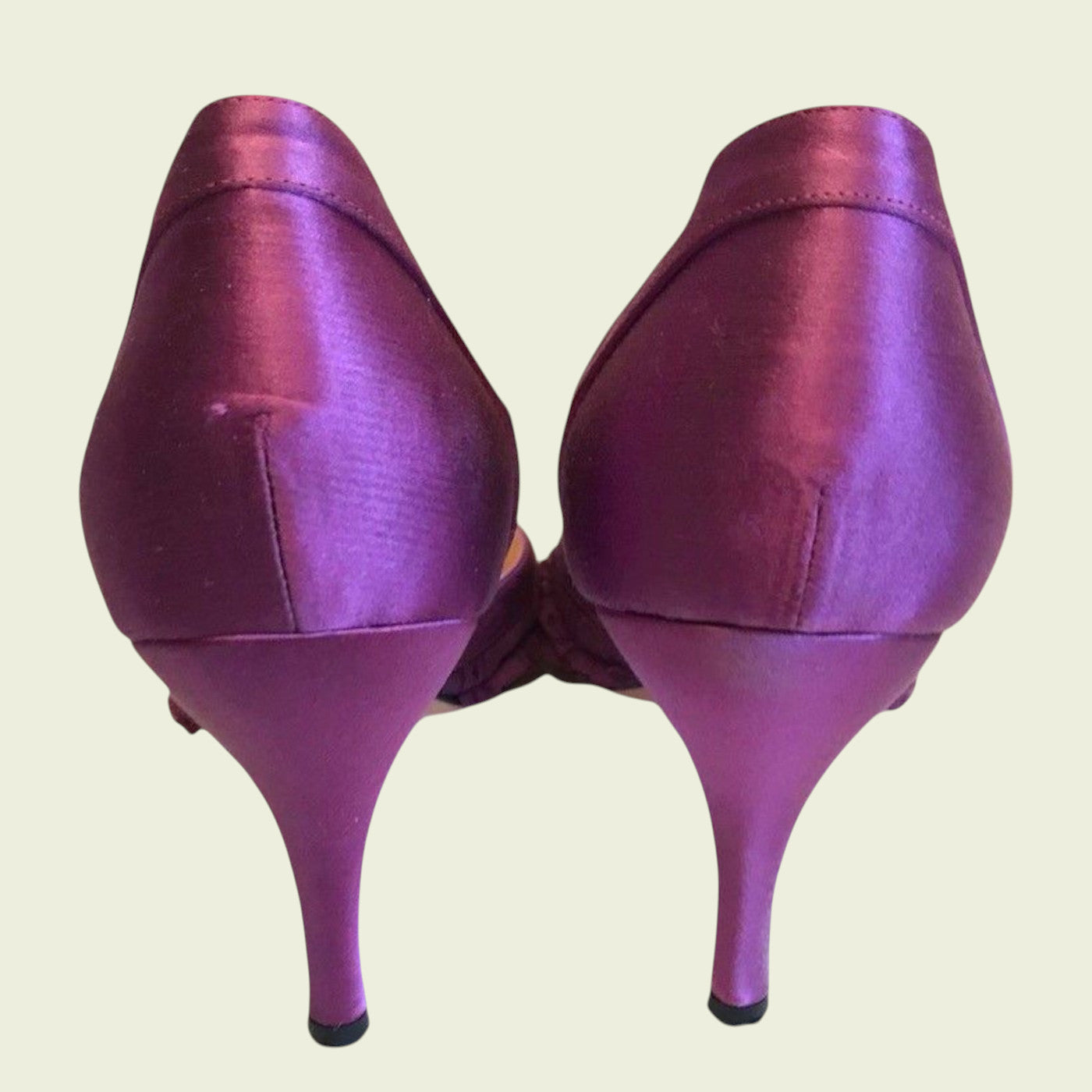 Purple high-heeled shoes on a beige background