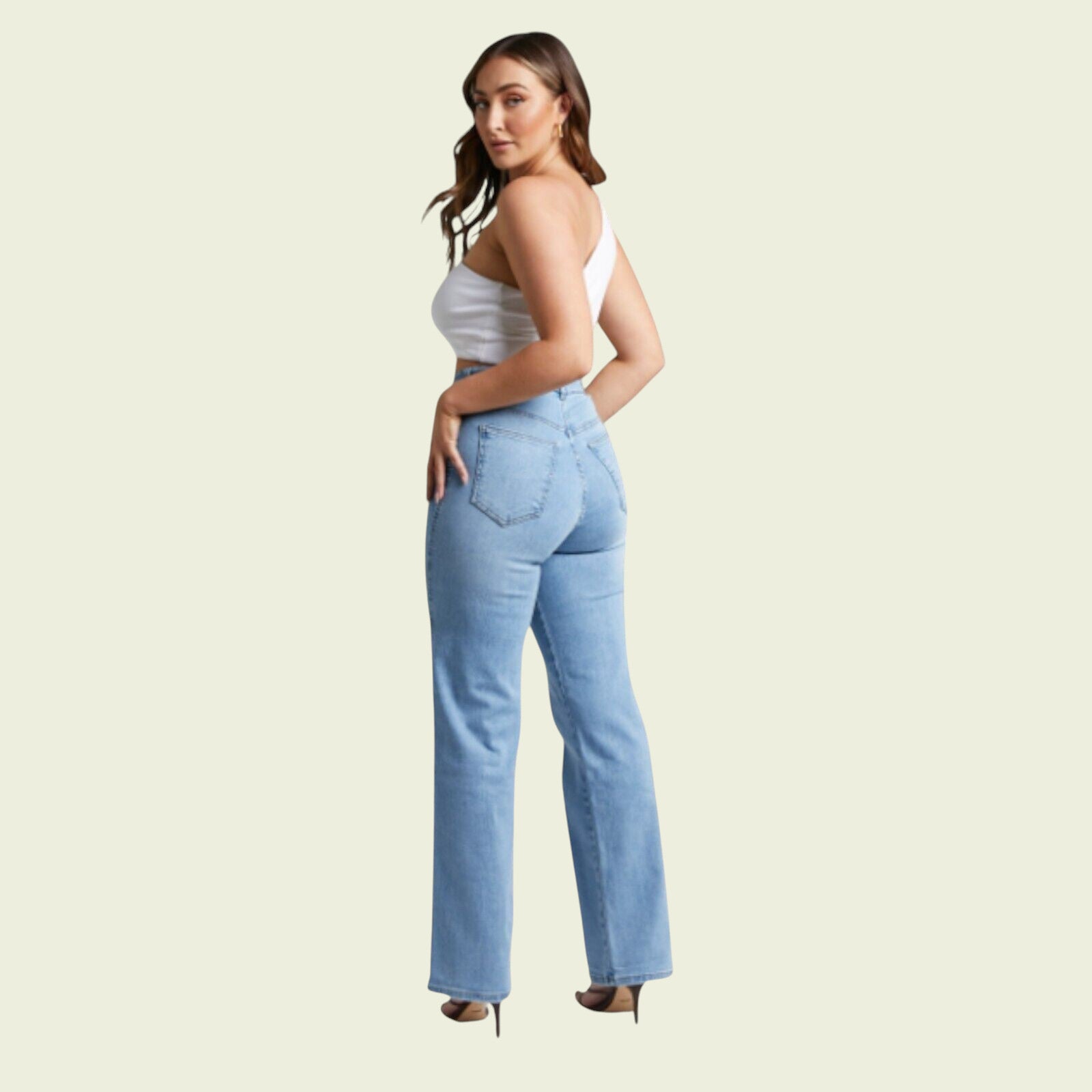 Woman wearing light blue jeans and a white top on a beige background