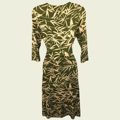 Green dress with beige leaf pattern on a beige background