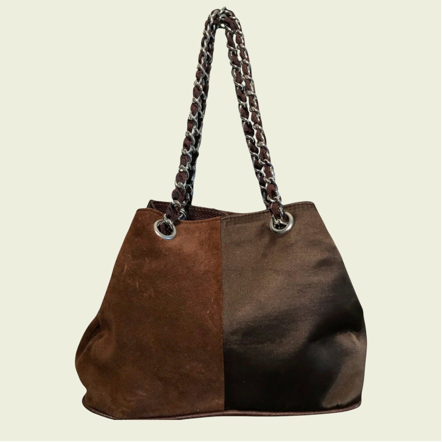 Brown handbag with braided handle on a beige background