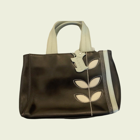 Brown handbag with leaf designs on a beige background