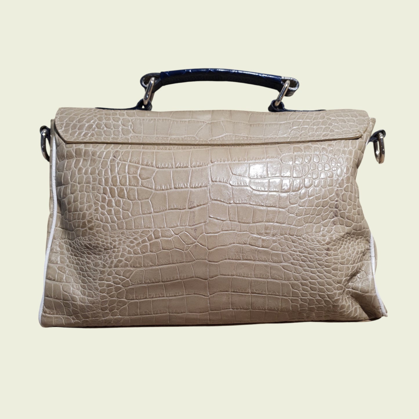 Beige handbag with crocodile texture on a light beige background