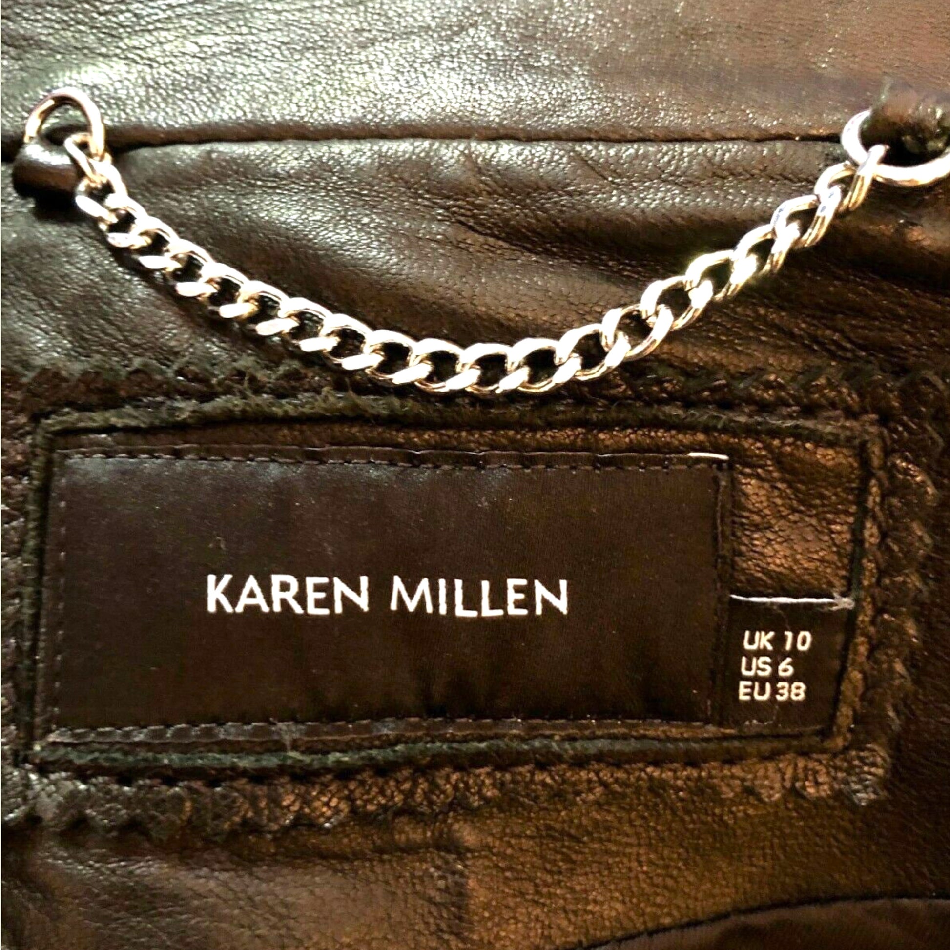 Brown leather garment with a 'Karen Millen' label and chain detail.