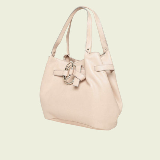 Pink handbag with a bow detail on a light beige background