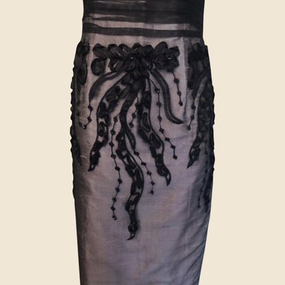 Dress with black floral embroidery on a beige background