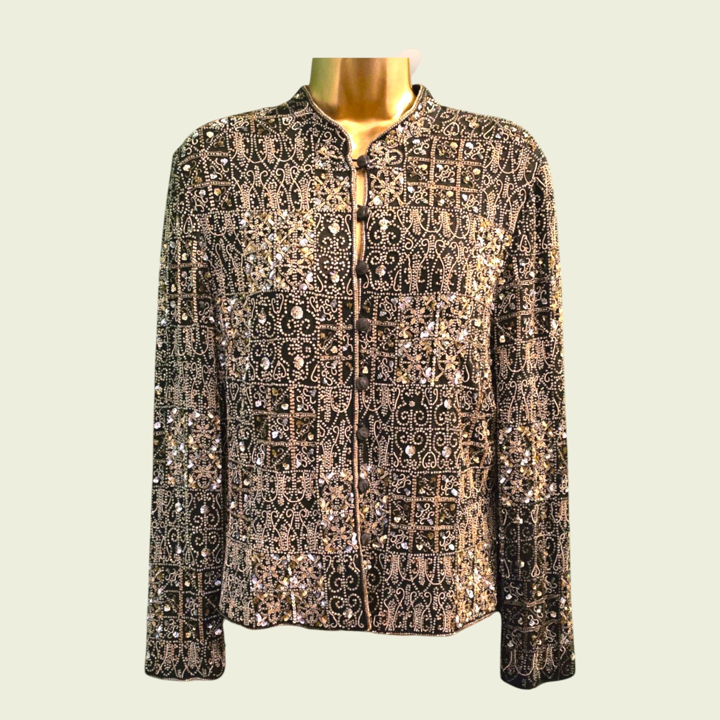 Elegant jacket with intricate patterns and embellishments on a mannequin against a light background