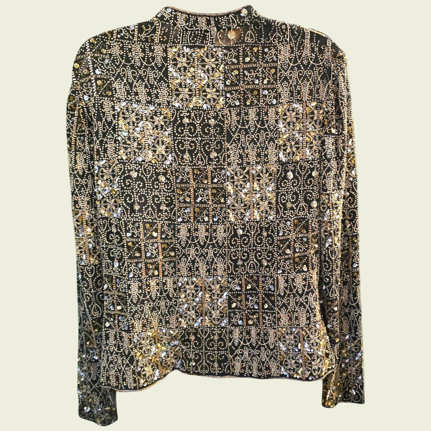 Elegant black jacket with gold and silver embellishments on a light beige background