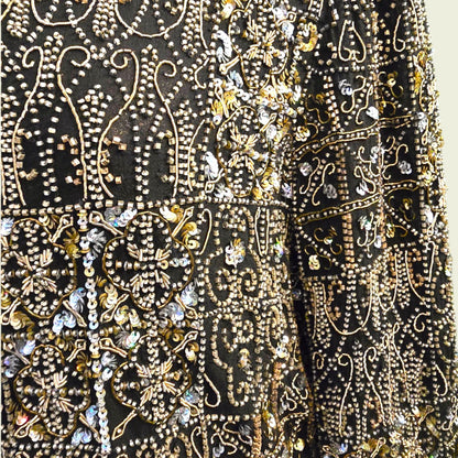 Close-up of a black fabric with gold and silver embroidery