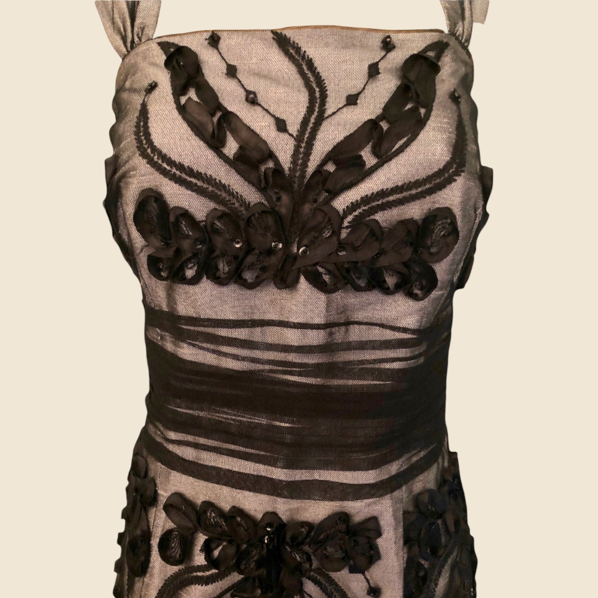 Dress with black floral embroidery on a beige background