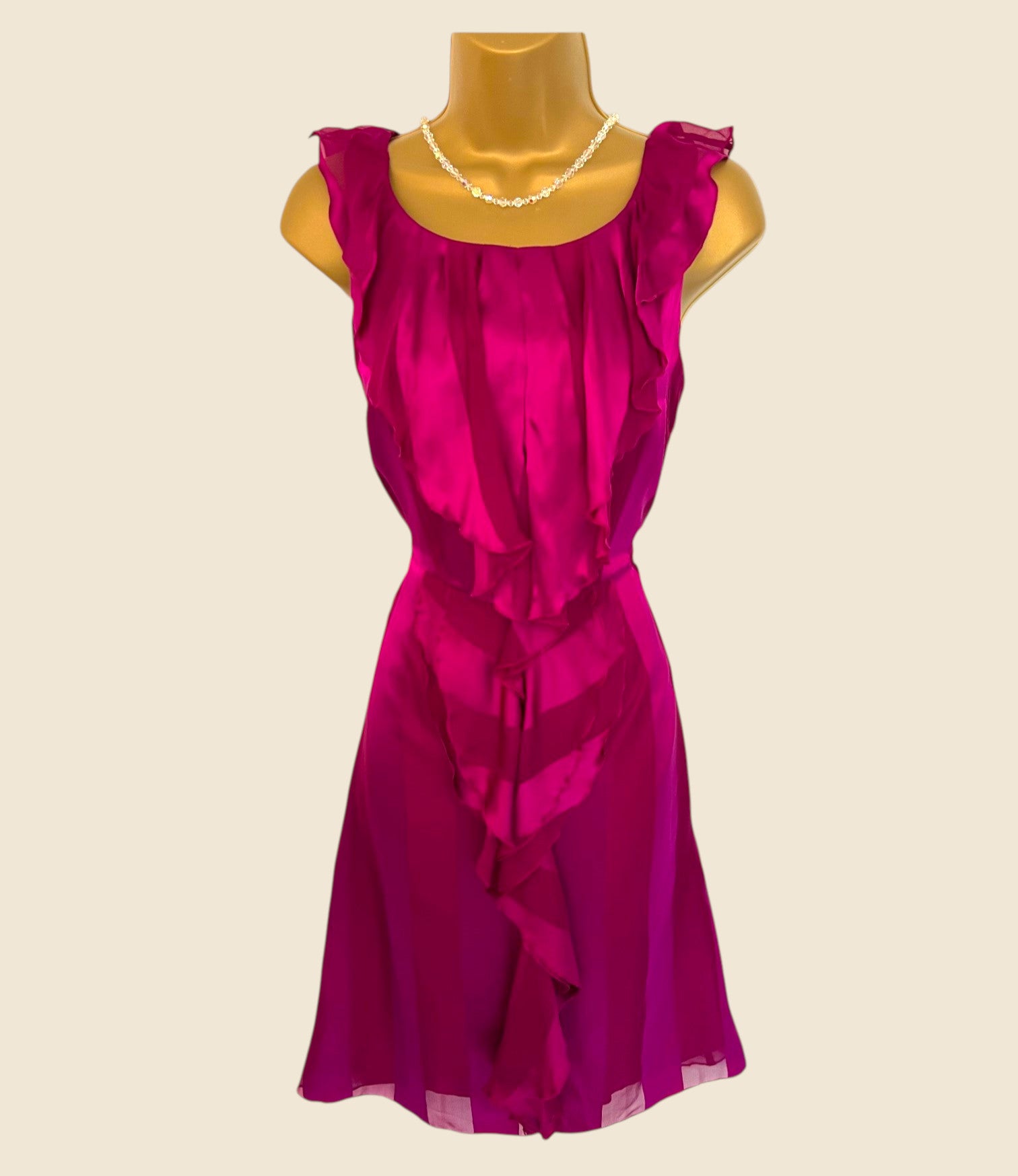 Fuchsia dress on a mannequin against a beige background
