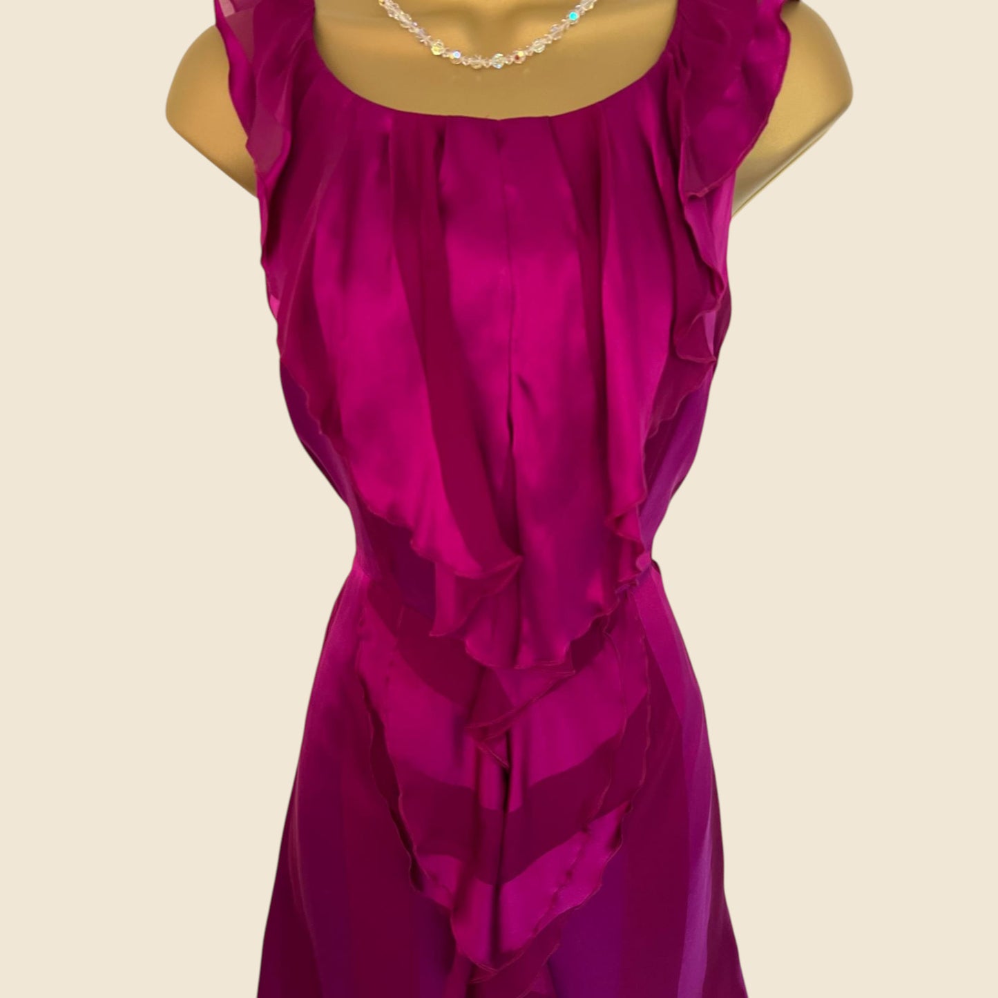 Mannequin wearing a magenta dress on a beige background