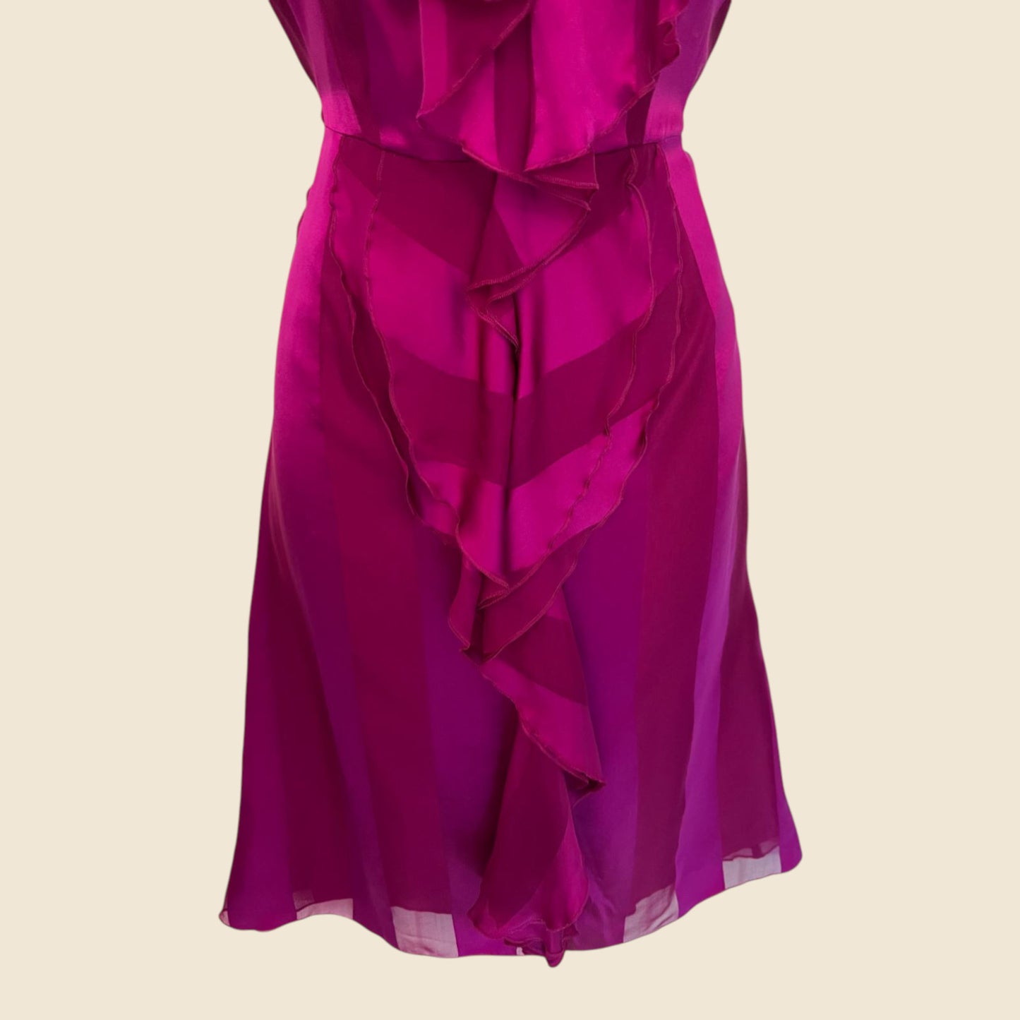 Fuchsia ruffled dress on a beige background