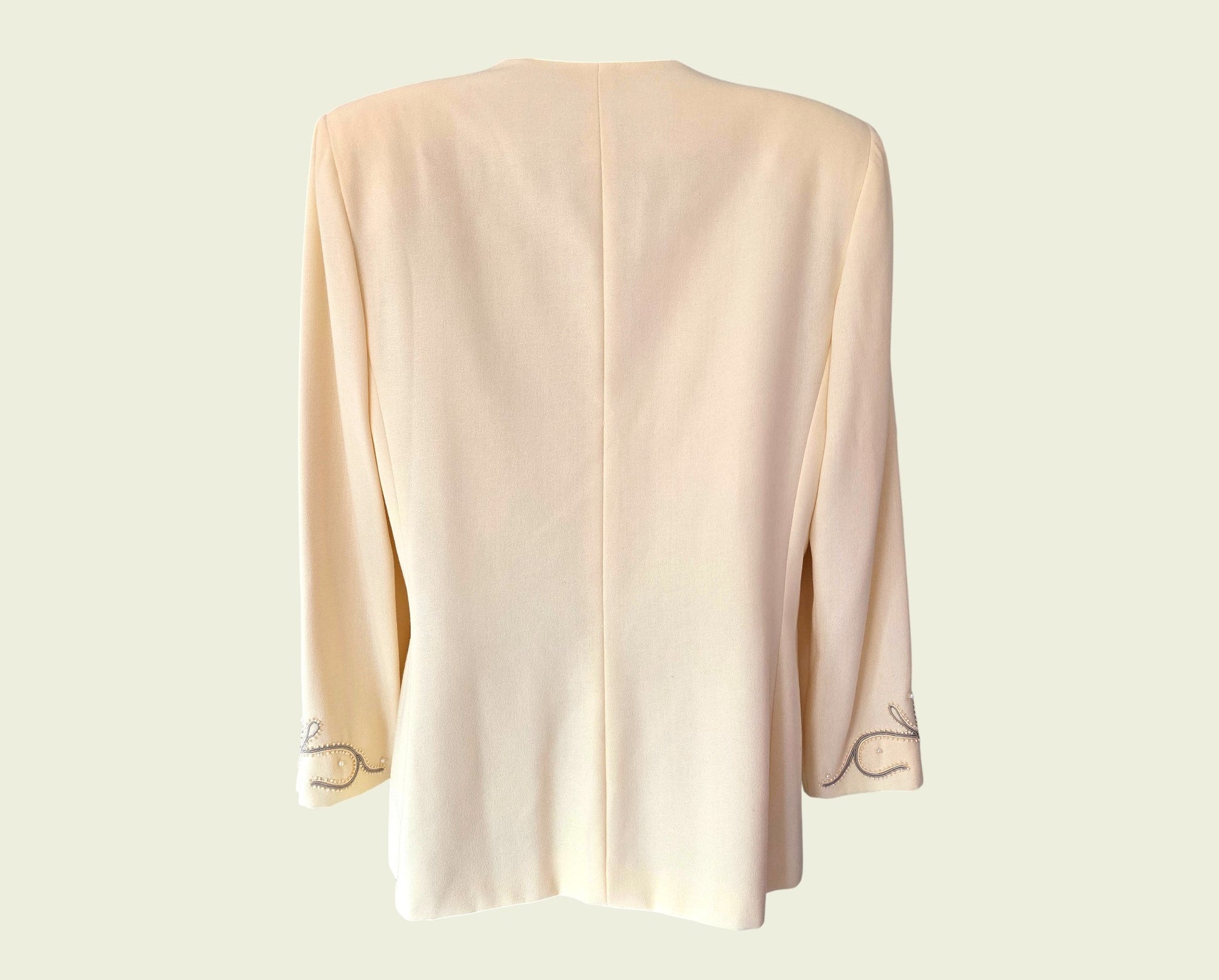 Yellow jacket with embroidered trim on a light beige background