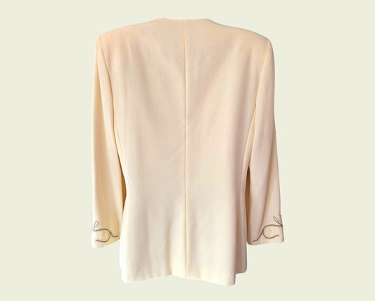 Yellow jacket with embroidered trim on a light beige background