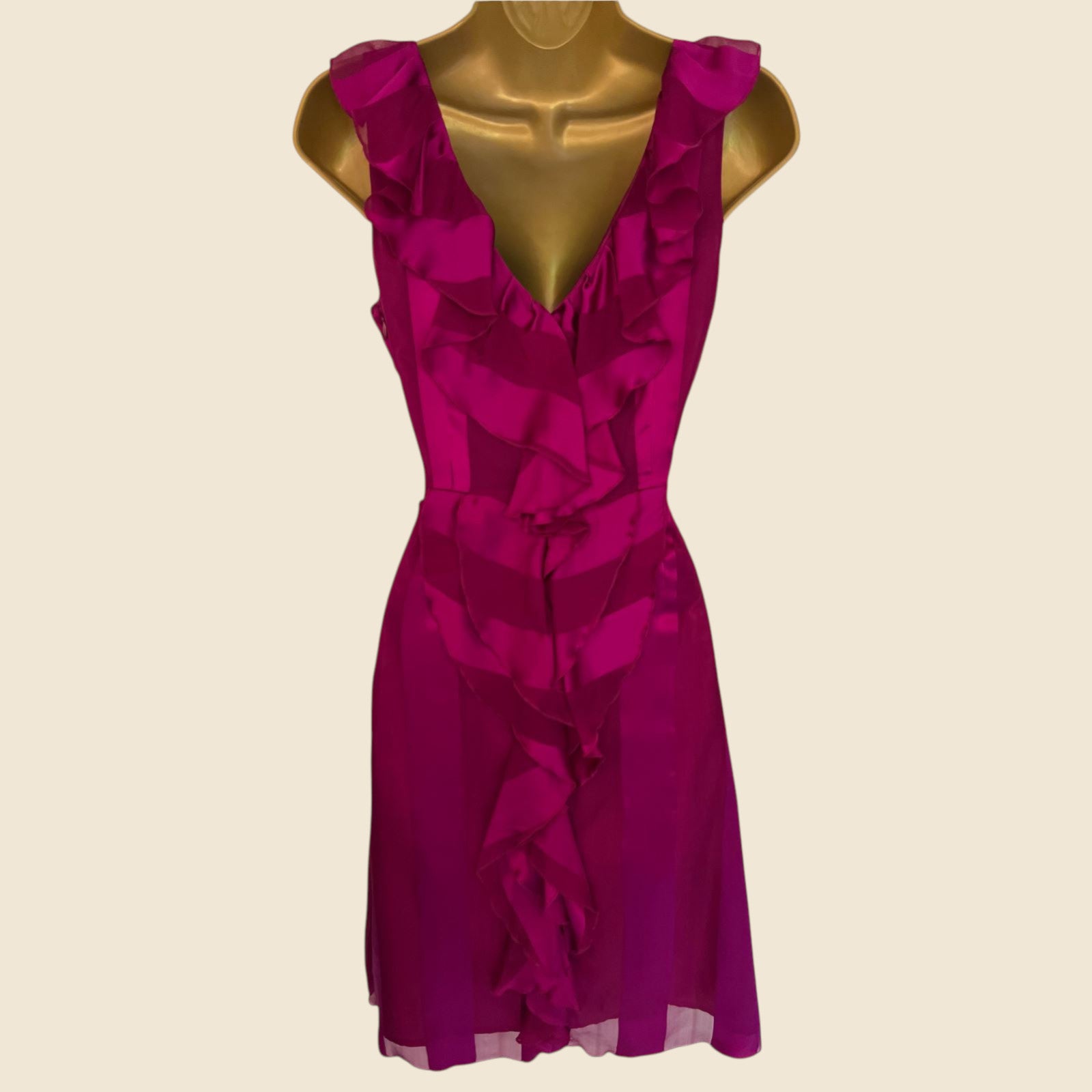 Fuchsia dress on a mannequin against a beige background