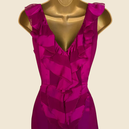 Fuchsia dress on a gold mannequin against a beige background