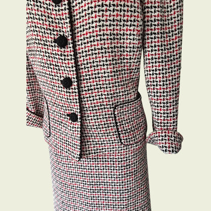 Houndstooth patterned suit with black buttons on a beige background