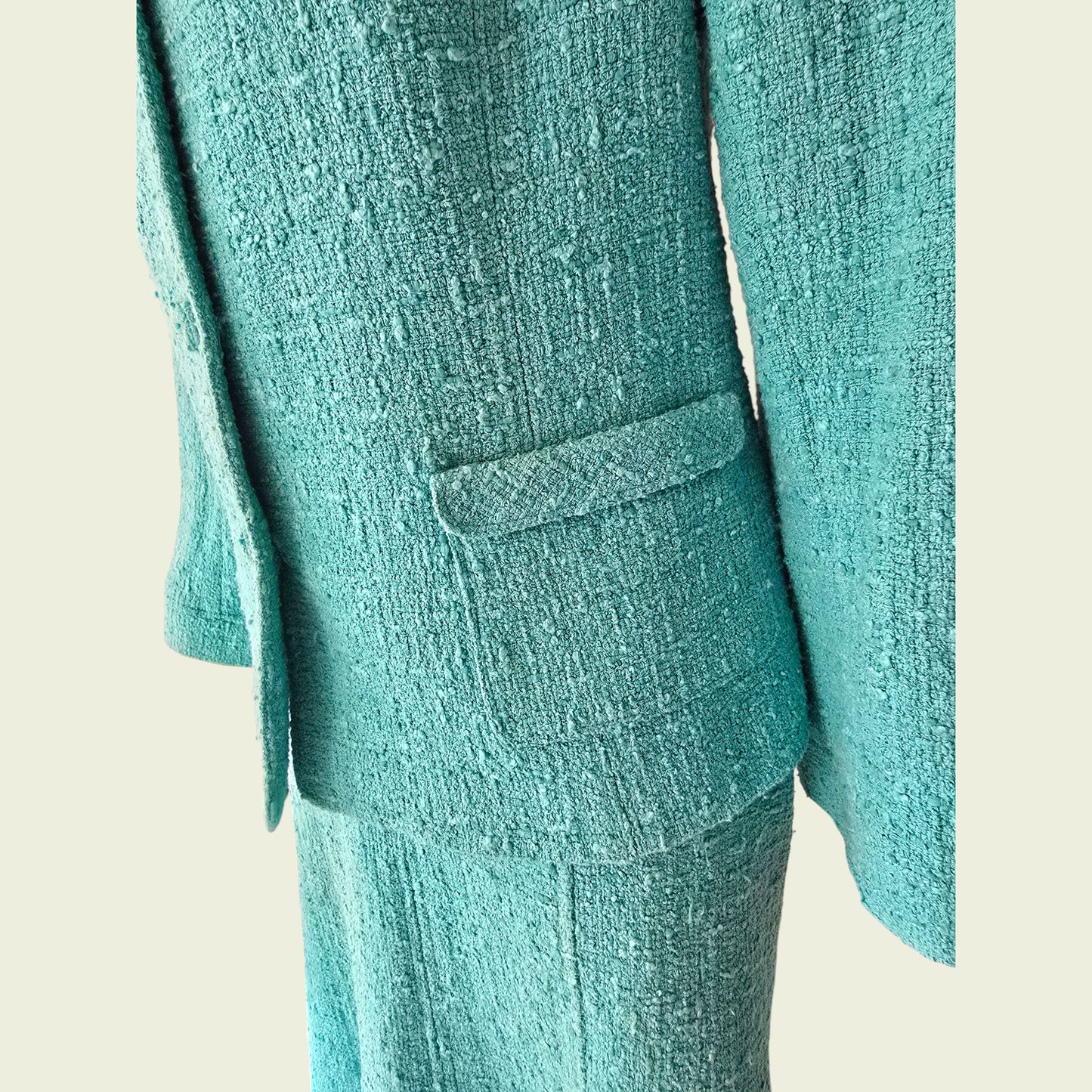 Turquoise textured blazer and pants on a light beige background