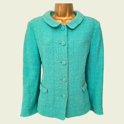 Turquoise jacket on a mannequin against a beige background