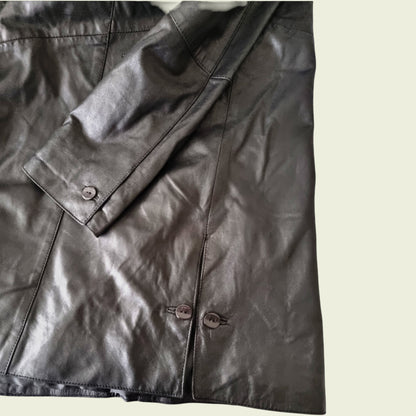 Close-up of a black leather jacket with buttons on a light background