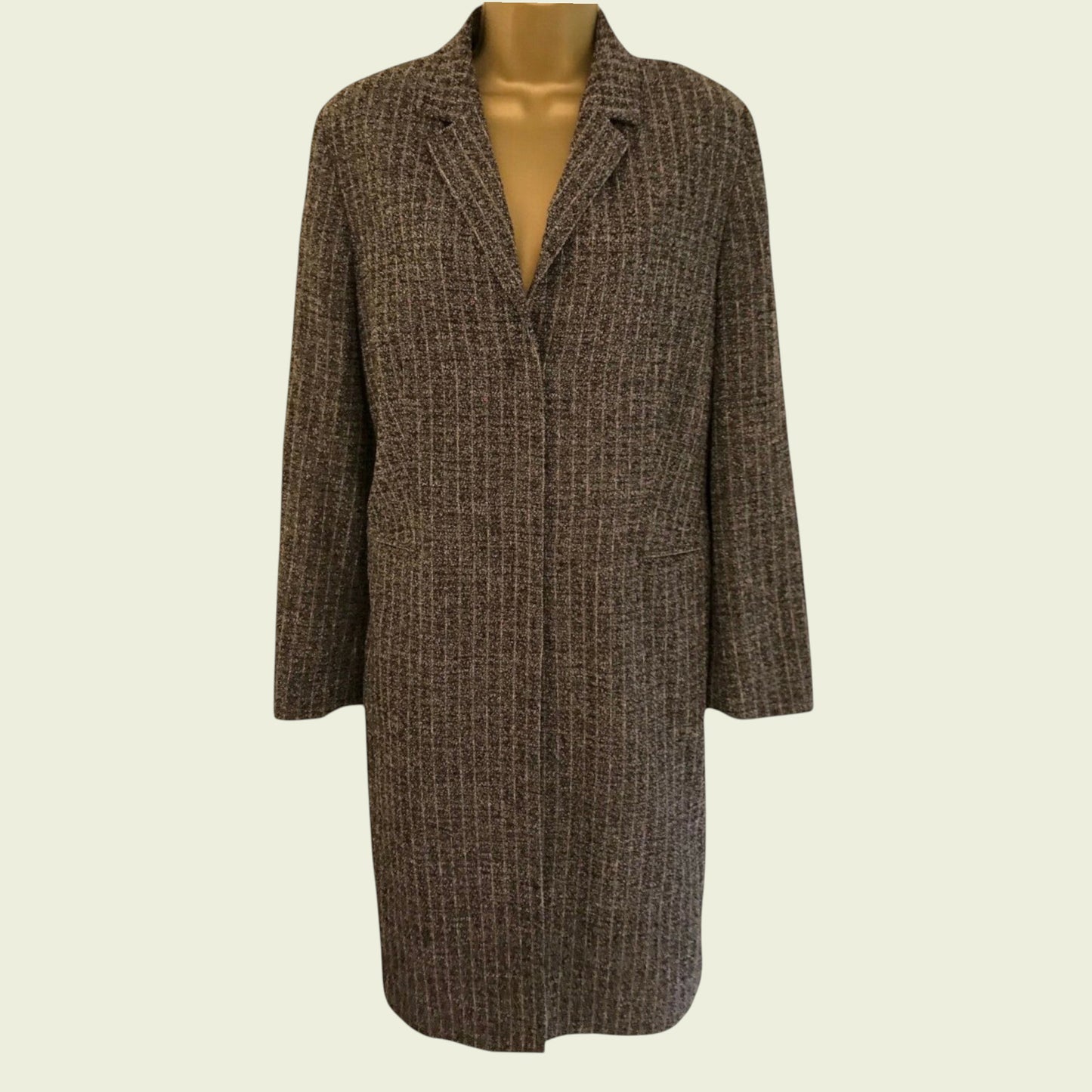 Brown checkered coat on a mannequin against a beige background