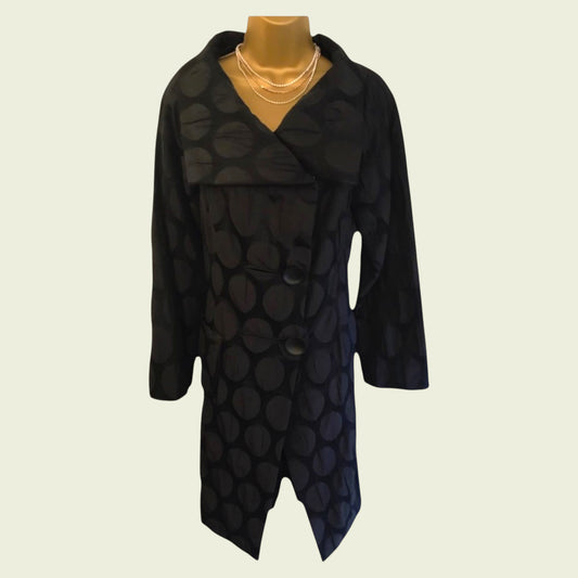 Black patterned coat on a mannequin against a beige background