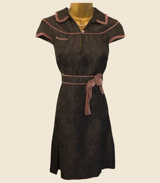 Brown dress with pink trim on a beige background
