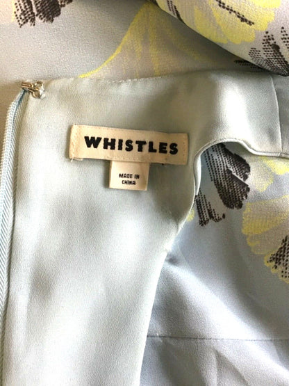 Close-up of a garment with 'Whistles' brand label on a floral background