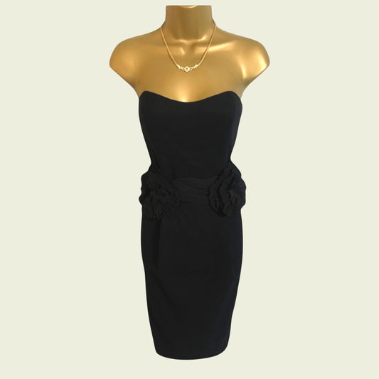 Black strapless dress on a gold mannequin with a plain background