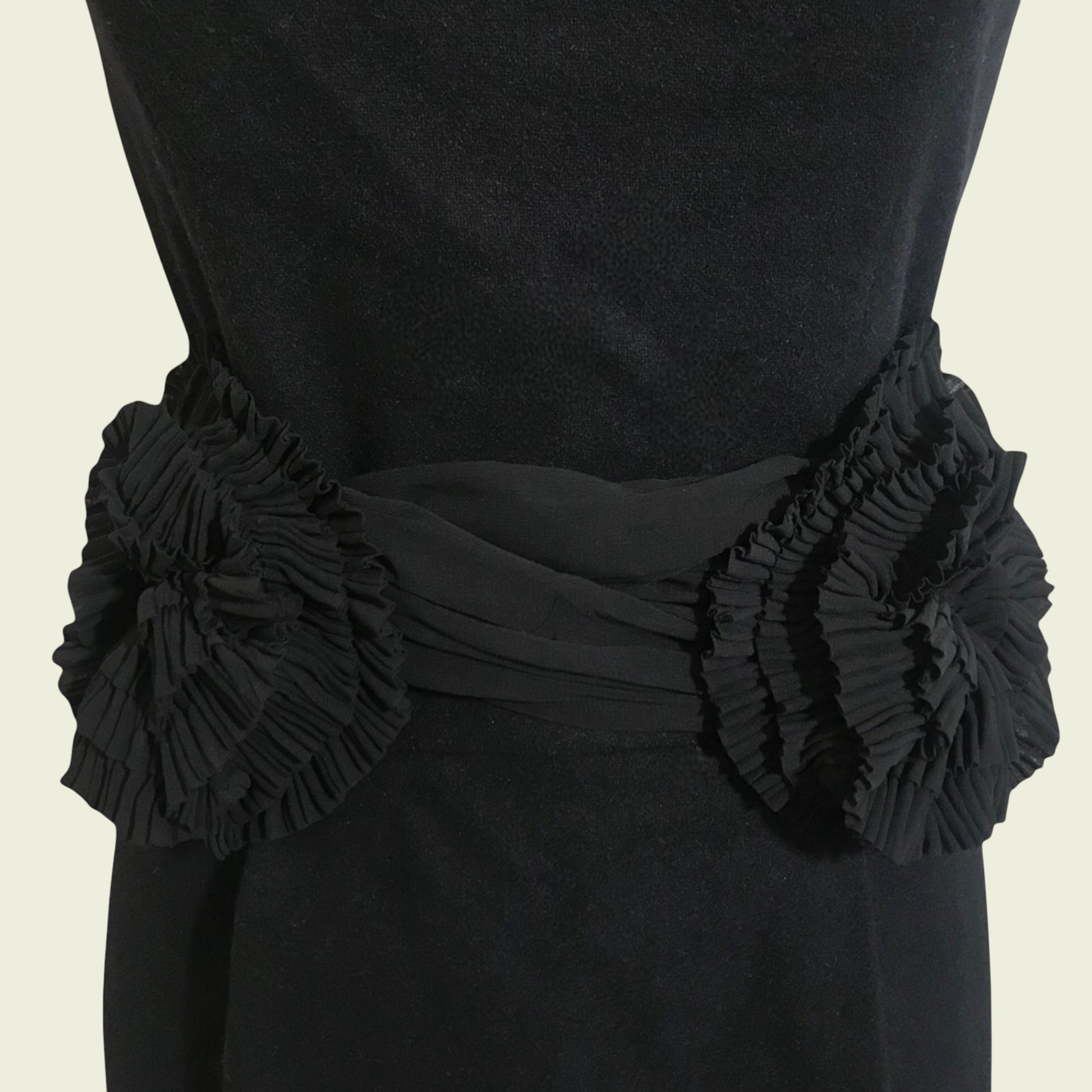 Black dress with floral embellishments on a beige background