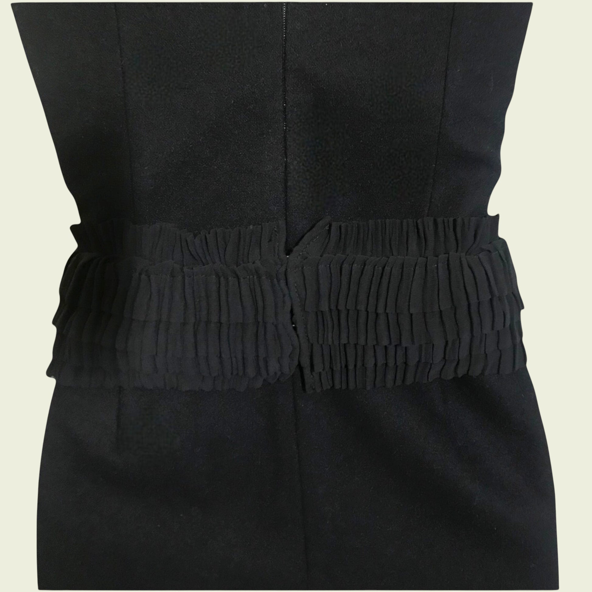 Black dress with a textured belt on a beige background