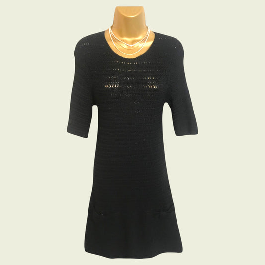 Black dress on a mannequin with a plain background