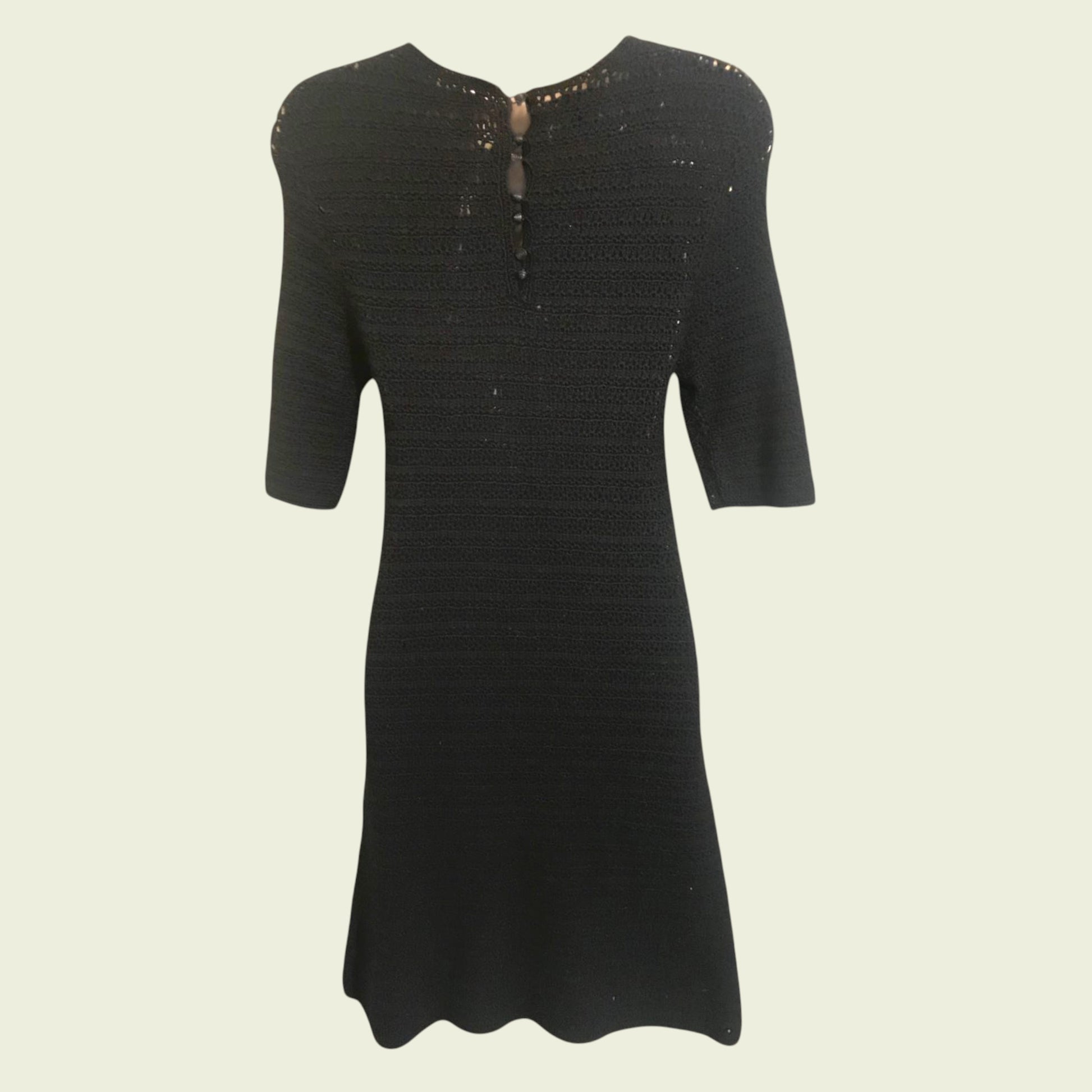 Black dress with short sleeves on a beige background