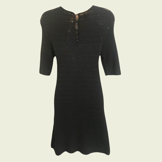 Black dress with short sleeves on a beige background