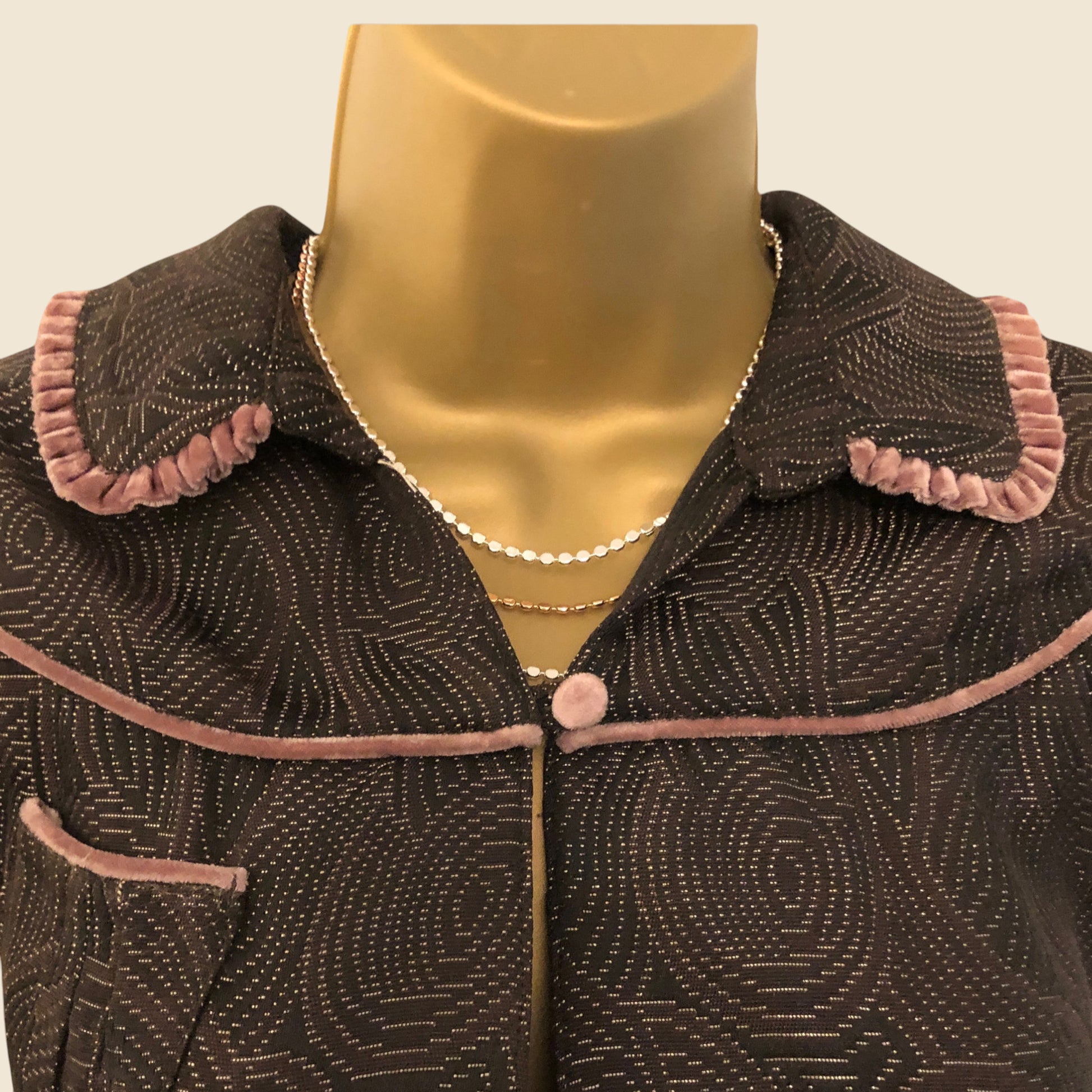 Brown textured collar with pink trim on a mannequin against a beige background