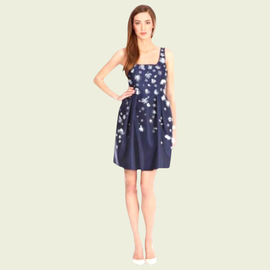 Woman wearing a navy blue dress with white patterns on a beige background