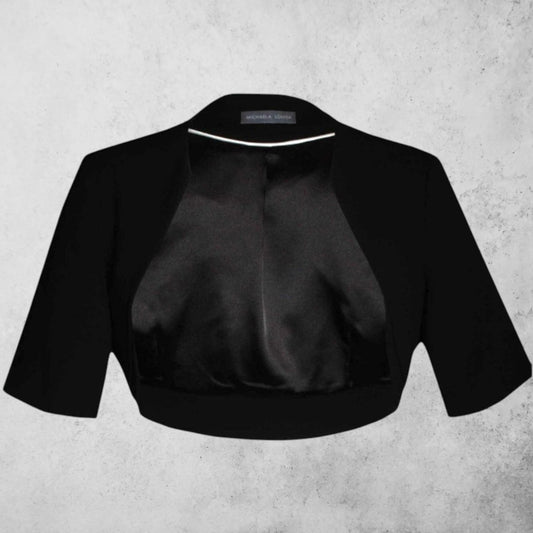 Black satin bolero jacket on a textured gray background