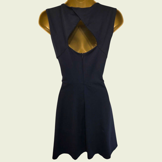Black dress with cut-out back on a mannequin against a beige background