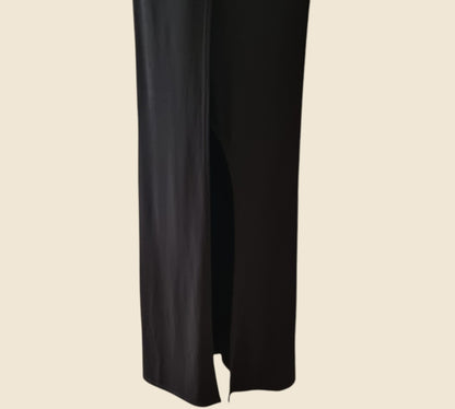 Black dress showing front split on a beige background