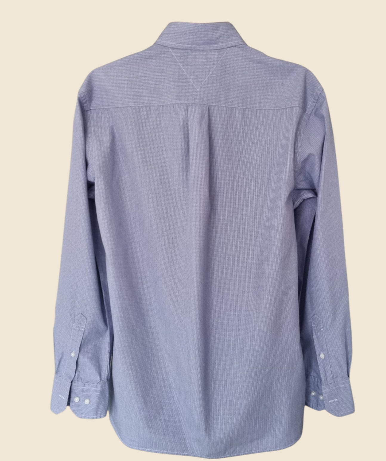 Blue button-up shirt on a beige background
