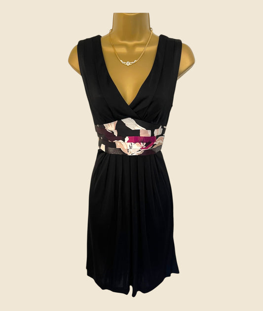 Black dress with a colorful waistband on a mannequin against a beige background