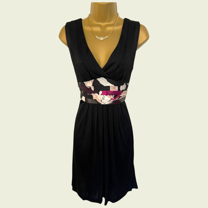 Black dress with floral belt on a mannequin against a beige background